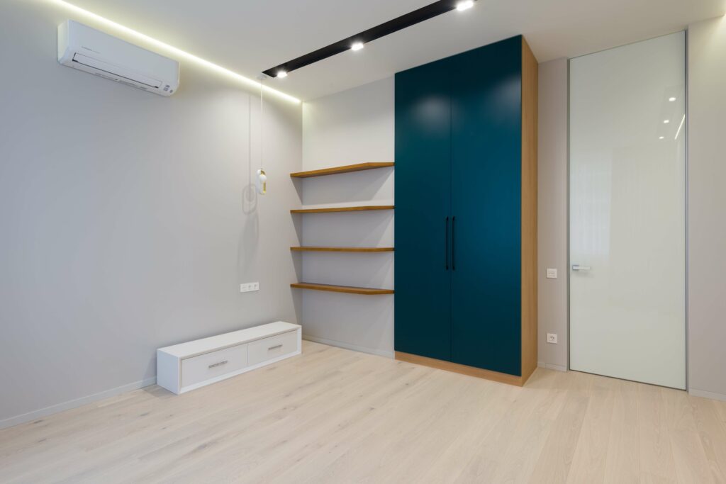 A modern and newly built aircondition room with a big 2-door black cabinet, 4-level hanging wood shelves, and ambient lighting thanks to the pinlights